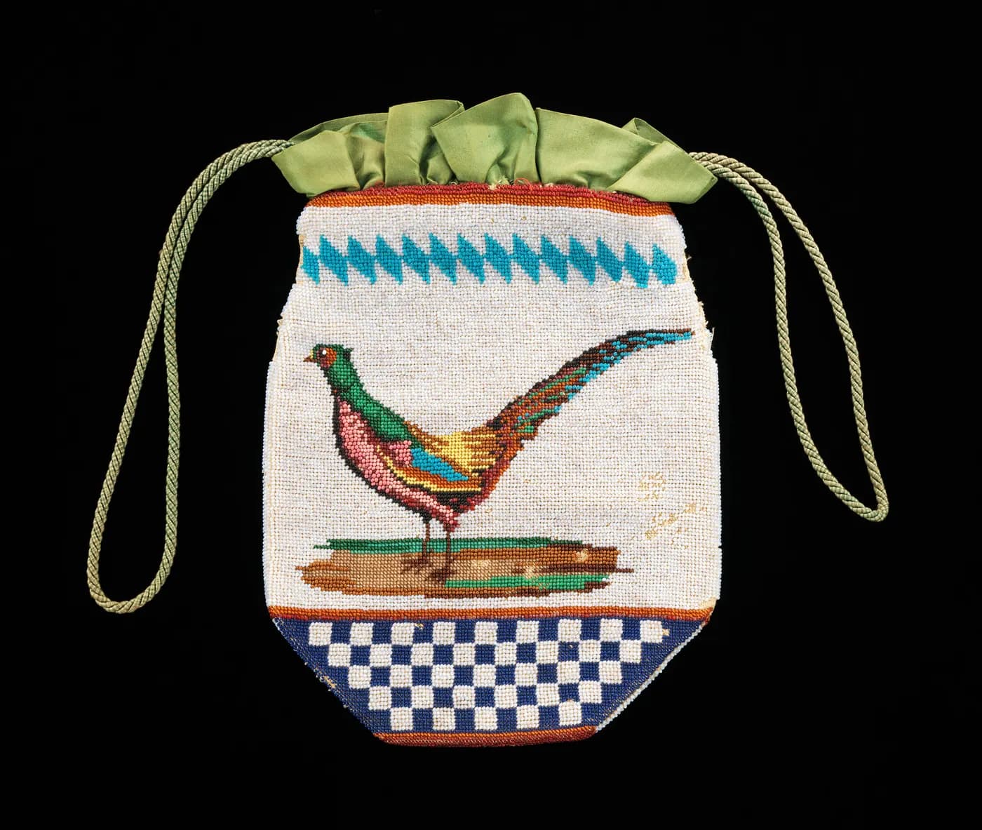 A beaded drawstring pouch with a pheasant above a blue and white chequerboard, green silk at the neck, on black.